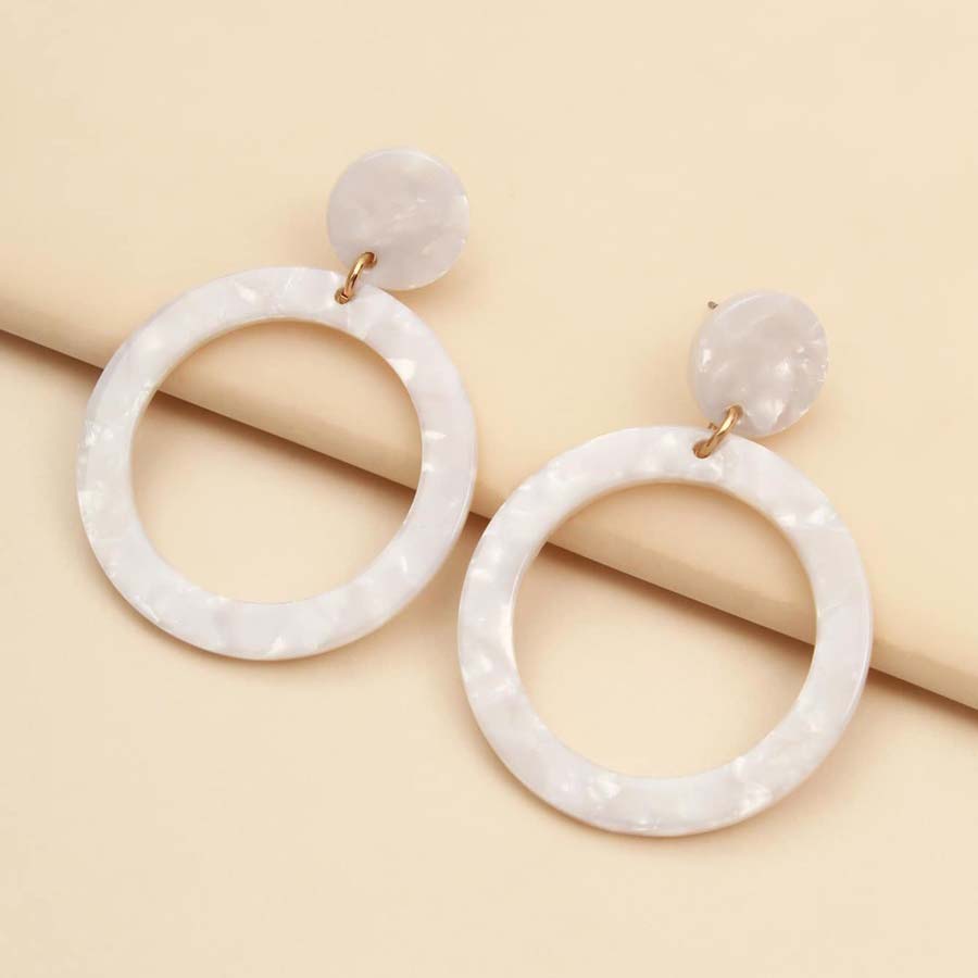 A close up of acrylic earrings on a table.