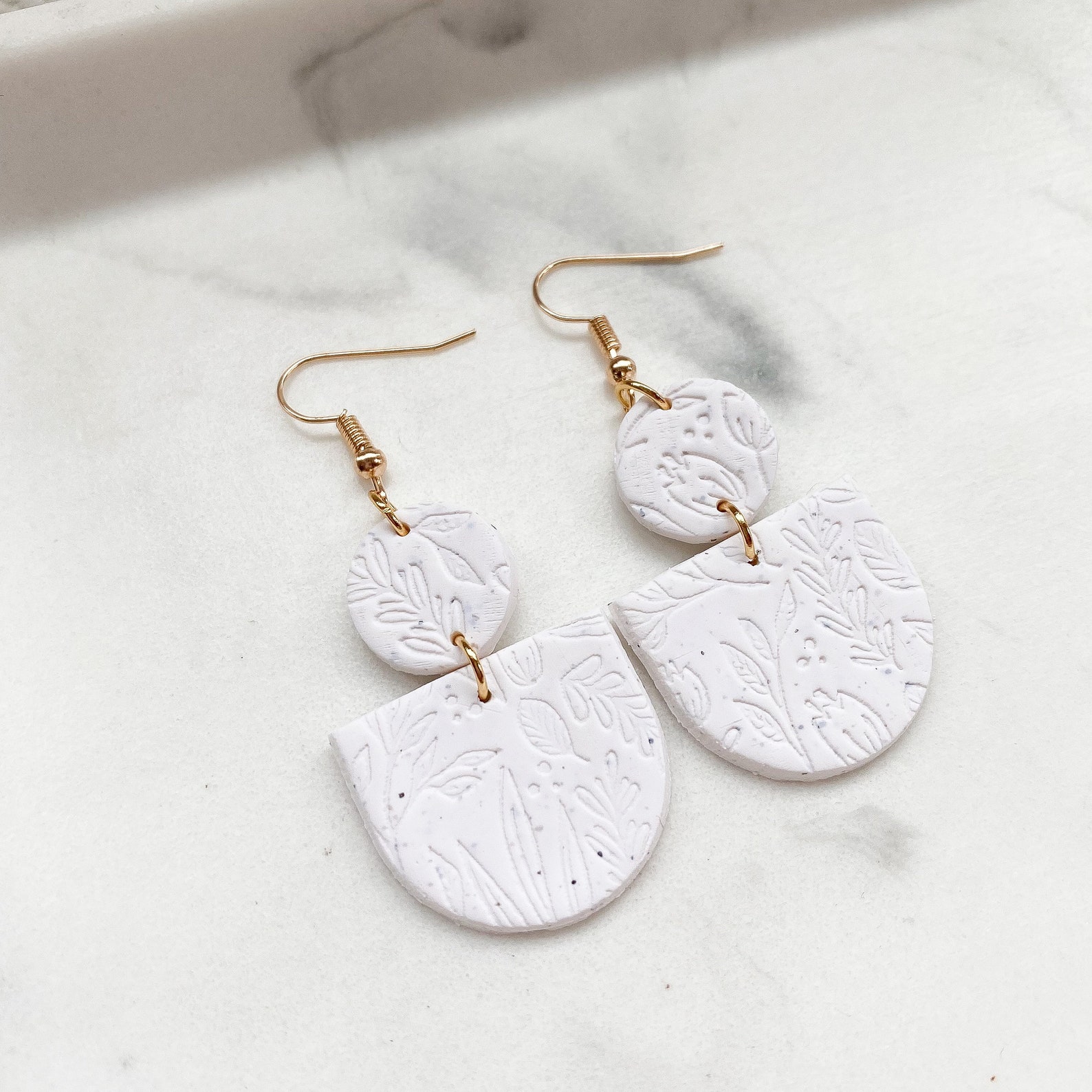 A close up of clay earrings on a table.
