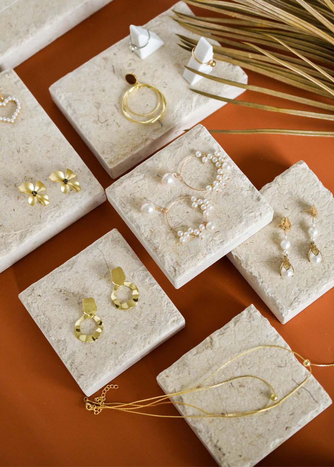 A table with earrings on stone slabs.
