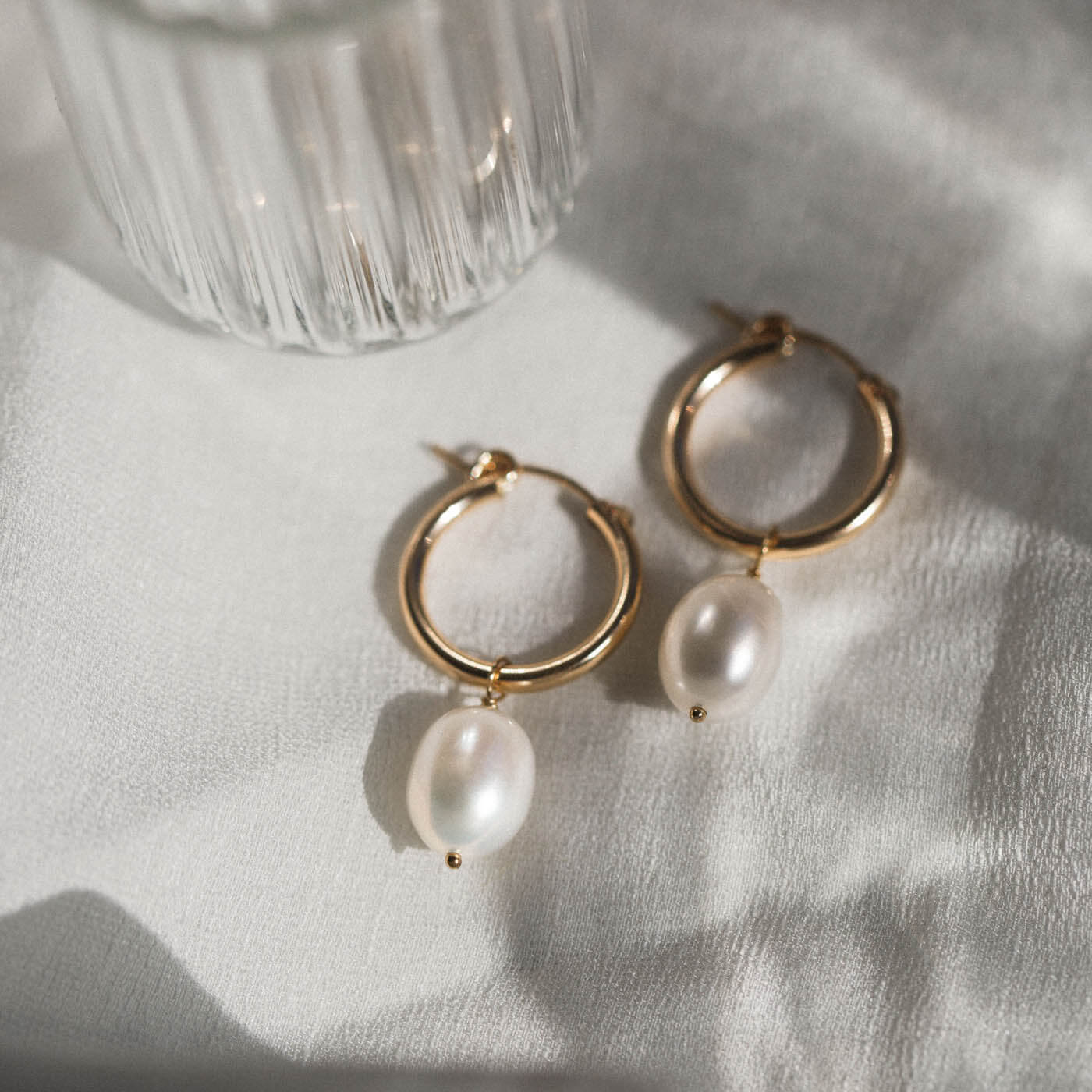 A close up of pearl earrings on a table.
