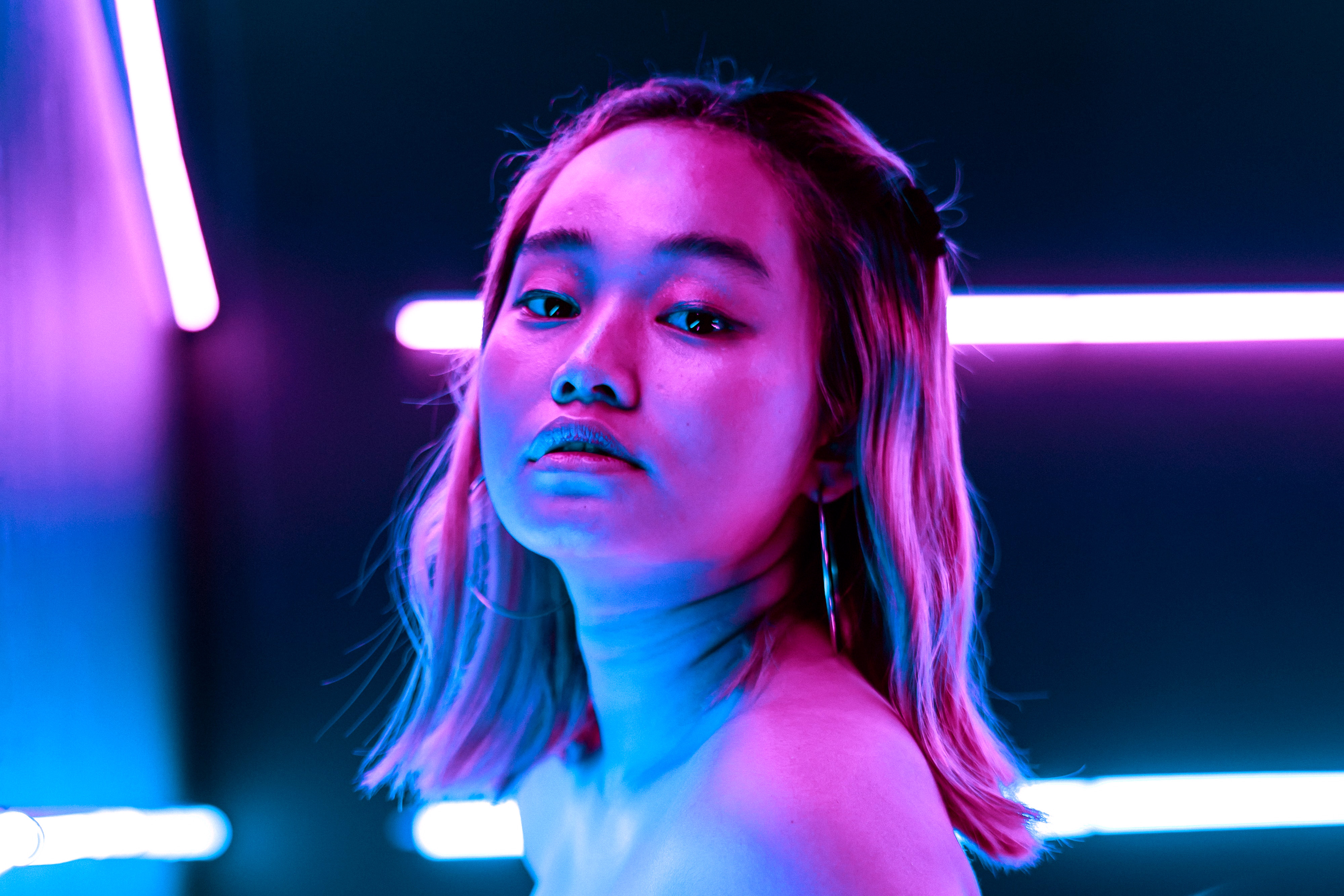 Portrait of a girl with pink and blue lighting.
