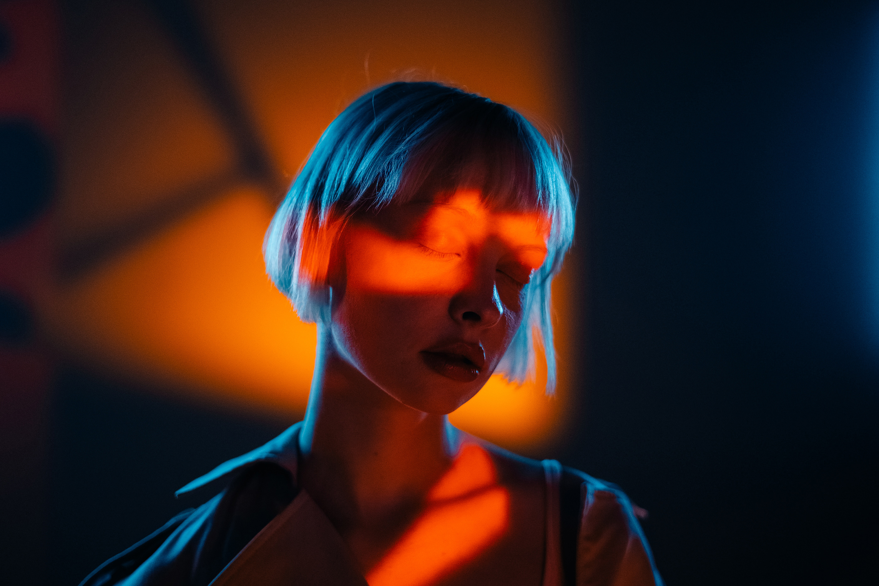 Photo of a woman with blue and orange lighting.